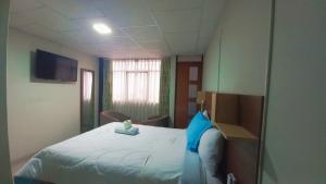 a hospital room with a bed with a blue pillow at Hotel Monte Roraima in Huancayo