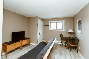 a living room with a bed and a television at Lone Star Motel in Rossland