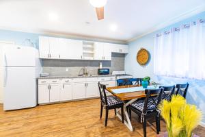 a kitchen with a table and chairs and a white refrigerator at Sunset Cottage at Viking Hill in Nassau
