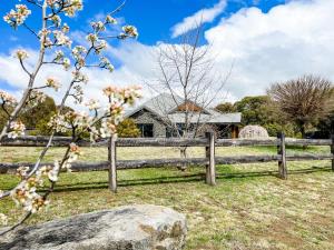 une vieille clôture en bois devant une maison dans l'établissement Hamilton House - Snowy Mountain Luxury Villas, à Jindabyne