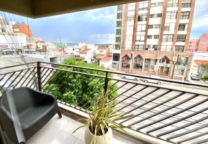 a balcony with a chair and a view of a city at Monoambiente de diseño confortable -Puerto Madryn in Puerto Madryn