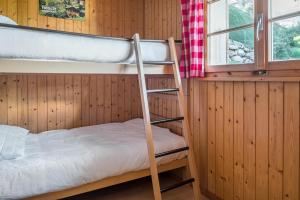 a bunk bed in a wooden room with a ladder at Wasserhügeli in Fiesch
