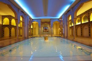 an indoor pool with a fountain in a building at Spa World HOTEL&RESORT in Osaka