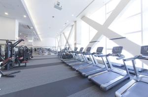a gym with rows of treadmills and ellipticals at Spa World HOTEL&RESORT in Osaka