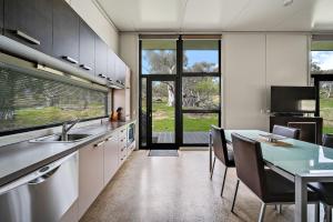 a kitchen with a sink and a table with chairs at Ecocrackenback 19 Sustainable chalet close to the slopes in Crackenback