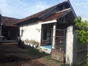 a house with a motorcycle parked in front of it at PRB Homestay in Pilang