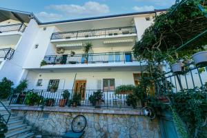 a white building with balconies and potted plants at Apartments by the sea Gradac, Makarska - 20041 in Gradac