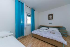 - une chambre avec un grand lit et des rideaux bleus dans l'établissement Apartments by the sea Gradac, Makarska - 20041, à Gradac