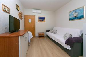 Cette petite chambre comprend un lit et une télévision. dans l'établissement Apartments by the sea Gradac, Makarska - 20041, à Gradac