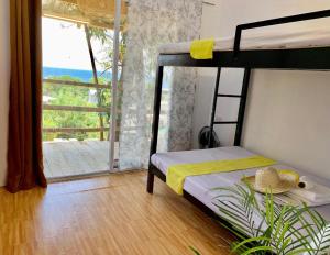 サンフアンにあるCasita Lodge Kuboのベッドルーム1室(二段ベッド2組付)、バルコニーが備わります。