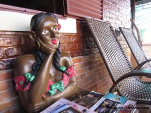 Una statua di una donna seduta su un tavolo di Pousada Sol de Verão a Barra do Garças