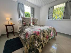 a bedroom with a bed and a table and windows at Waterfront paradise 2 br; stunning sunsets in Bora Bora