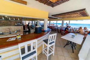 WOW location Kite Beach Oceanfront 2 Bedroom Patio and Pool في كاباريتي: بار في مطعم مع المحيط في الخلفية