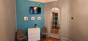 Hotel Voila Londres في سانتياغو: غرفة بحائط ازرق مع كرسيين وكابينة