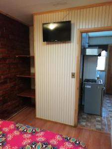 a room with a wall with a television and a stove at Cabañas Avenida España in Punta Arenas