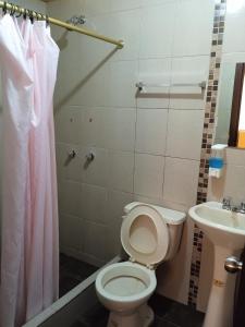 a bathroom with a toilet and a sink at Hotel Residencial Miraflores in Loja