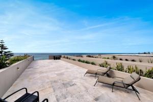 d'une terrasse avec des chaises et l'océan en arrière-plan. dans l'établissement Paradise Penthouse - Beach Front Style and Luxury, à Entrance