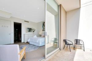 1 dormitorio con 1 cama, mesa y sillas en Paradise Penthouse - Beach Front Style and Luxury, en The Entrance