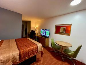 Habitación de hotel con cama, mesa y TV en Sibley Inn, en Sibley