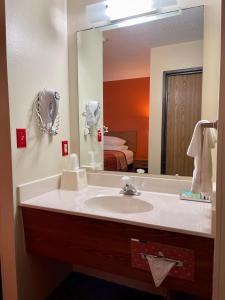 a bathroom with a sink and a large mirror at Sibley Inn in Sibley