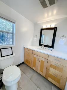 a bathroom with a toilet and a sink and a mirror at Pristine 1BD/1BA Bungalow + Hot Tub - Ocean Park in Los Angeles