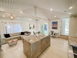 Il dispose d'une cuisine et d'un salon avec un canapé et une table. dans l'établissement Pristine 1BD/1BA Bungalow + Hot Tub - Ocean Park, à Los Angeles