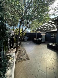 un patio avec un arbre et des tables ainsi qu'un bâtiment dans l'établissement Pristine 1BD/1BA Bungalow + Hot Tub - Ocean Park, à Los Angeles