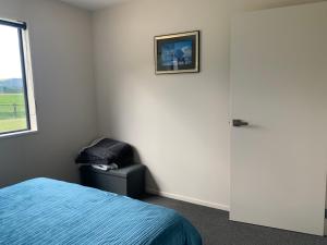 a bedroom with a bed and a chair next to a window at Guest Suite in Peaceful Location Roxburgh 