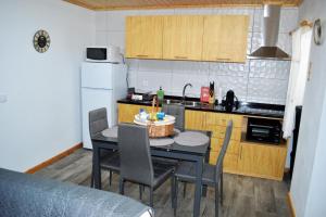 a kitchen with a table and chairs in a kitchen at Casa do Arrodeio in São Mateus