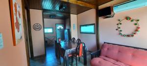 a dining room with a table and a pink couch at Brisas de Killa in General Rodríguez