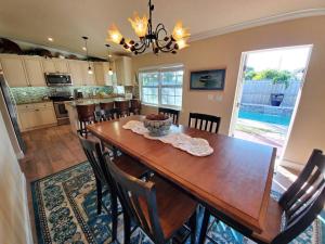 cocina y comedor con mesa de madera y sillas en Bahamian Cottage - Heated Pool Walk to the Beach en Cocoa Beach