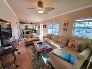 a living room with a couch and a table at Bahamian Cottage - Heated Pool Walk to the Beach in Cocoa Beach