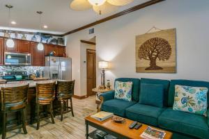 Una sala de estar con un sofá azul y una cocina. en Entire Villa - Sleeps 16 Heated Pool East of A1A, en Cocoa Beach