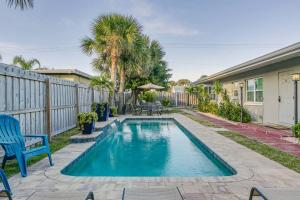 una piscina con una silla azul y una valla en Entire Villa - Sleeps 16 Heated Pool East of A1A, en Cocoa Beach