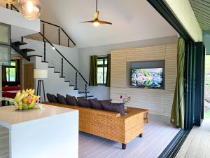 uma sala de estar com um sofá e uma televisão em Fare To'erau - New cozy vacation home on Bora Bora em Bora Bora