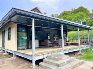ein Haus mit Glastüren und einer Terrasse in der Unterkunft Fare To'erau - New cozy vacation home on Bora Bora in Bora Bora