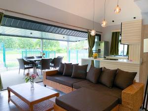 sala de estar con sofá y mesa en Fare To'erau - New cozy vacation home on Bora Bora en Bora Bora