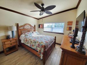 a bedroom with a bed and a ceiling fan at Hawaiian Cottage - Heated Pool Walk to the Beach in Cocoa Beach