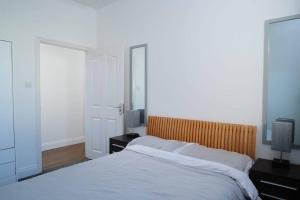 een slaapkamer met een bed, 2 lampen en een spiegel bij The Lodge - Newly Refurbished Suite with Dedicated Office Space in Weybridge