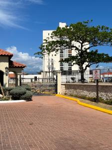 a street with a fence and a tree in front of a building at Large Luxurious Beach Front 1 Bedroom at Bayfront Villa in Portmore