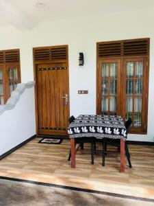a table in the middle of a room with a door at Ramesh Guesthouse in Mirissa