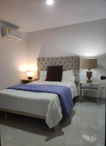 1 dormitorio con 1 cama grande con manta azul en Comfort Rooms Barranquilla Zafiro Deux, en Barranquilla