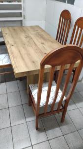 een houten tafel met twee stoelen en een houten tafel en een tafel en een stoeltje bij Hostel da Floresta in Vitória