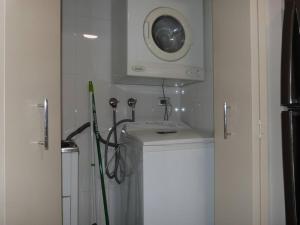a bathroom with a sink and a washing machine at Ultra Convenient Apartment HER09029 in Sydney