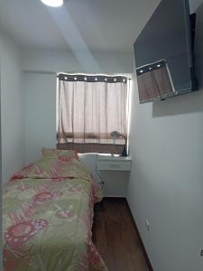 - une petite chambre avec un lit et une fenêtre dans l'établissement MWhite'sHome, à Lima