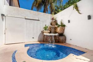 a small swimming pool with a fountain in a backyard at Villa Azul in Acapulco
