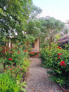 un jardín con flores rojas frente a una casa en Crocodile Safari Camp, en Chitwan