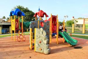 un parque infantil con varios tipos diferentes de equipos de juego en Summer all year! Oceanfront with Pool A/C, en Aguadilla