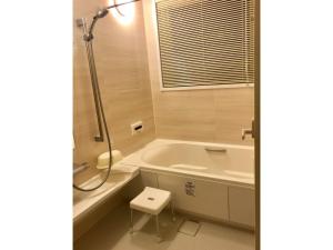 a bathroom with a tub and a toilet and a sink at Farm Inn Torch A - Vacation STAY 92716v in Tsurui