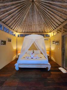 a bedroom with a bed with a mosquito net at Bamboo Lodge 2 in Gili Trawangan